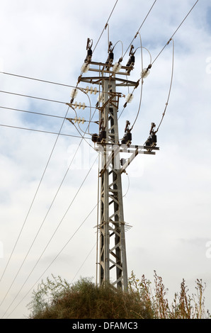 Una energia elettrica di tensione media pylon / power pole oltre il cielo nuvoloso Foto Stock