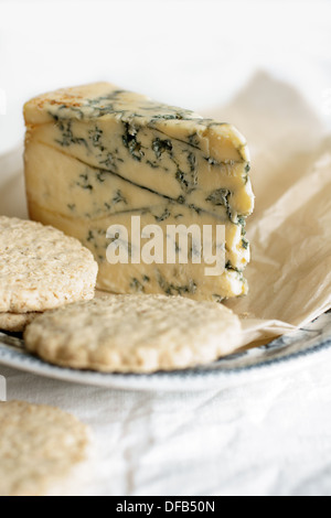 Del formaggio Stilton su di età compresa la carta pergamena con biscotti di avena Foto Stock