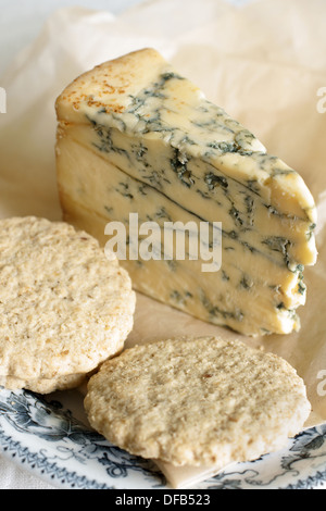 Del formaggio Stilton su di età compresa la carta pergamena con biscotti di avena Foto Stock