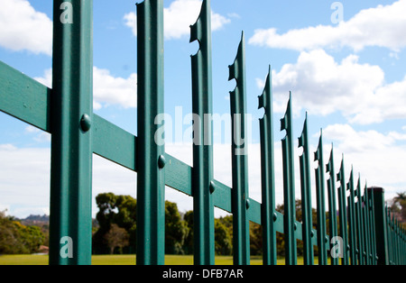Primo piano di acciaio verde palizzata recinto di sicurezza e cielo blu e nuvole Foto Stock