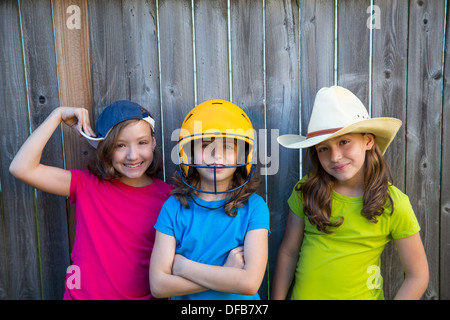 Sorella e amici sport kid ragazze ritratto sorride felice su grigio recinzione cortile di legno Foto Stock