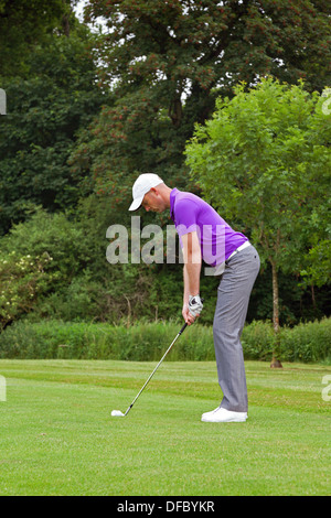 Foto di un golfista affrontando la palla e giocare un colpo a cuneo nel verde. Serie di cinque nel set. Foto Stock