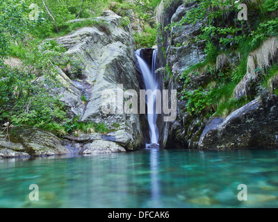 Cascata con piccolo lago delle Alpi italiane nella Valle Grande Foto Stock