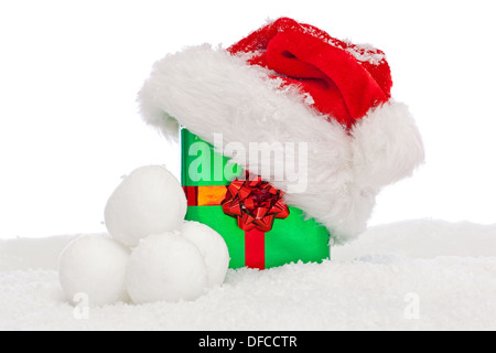 Un cappello da Babbo Natale sulla cima di un verde regalo regalo di Natale con un nastro rosso e la prua Foto Stock