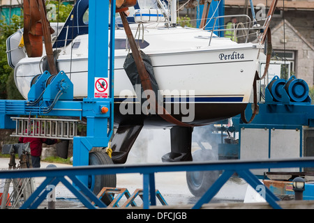 Cantiere operaio di pulitura a vapore barca sul paranco Foto Stock