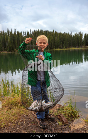 Ragazzo giovane mostrare le trote che ha pescato nel Lago Eggleston, Grand Mesa National Forest, Colorado, STATI UNITI D'AMERICA Foto Stock