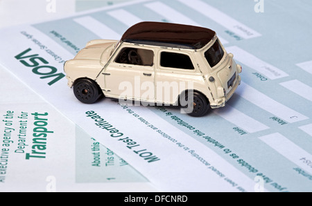 Primo piano di un'auto giocattolo Mini Cooper per bambini su MOT test Certificate Transport Business Motoring Concept Regno Unito Regno Unito Gran Bretagna Foto Stock