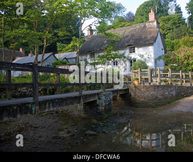 Piuttosto tradizionale cottage con il tetto di paglia nel villaggio di Helford, Cornwall, Regno Unito Foto Stock