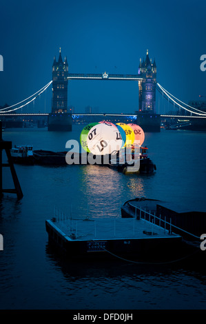 Regno Unito Lotteria Nazionale sfere sul Fiume Tamigi di fronte il Tower Bridge di Londra. Foto Stock