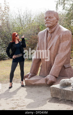 Donna ungherese puntare il dito alla statua di Lenin mentre visitano Memento Parco delle Statue di Budapest, in Ungheria Foto Stock