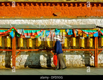 Un Buddista lady la filatura ruote della preghiera al di fuori del palazzo del Potala a Lhasa, in Tibet. Foto Stock