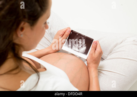 Donna incinta guardando al bambino di scansione a ultrasuoni Foto Stock