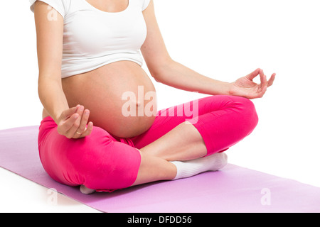 Donna incinta seduta yoga in posizione del loto Foto Stock