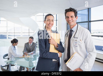 Ritratto di sorridere imprenditrice e dottore in riunione