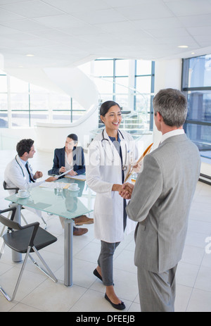 Medico e imprenditore stringono le mani in riunione Foto Stock