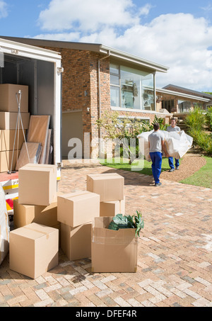 Movers trasportare divano dal movimento van a casa nuova Foto Stock