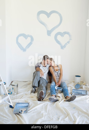 Giovane pittura cuori blu sulla parete Foto Stock