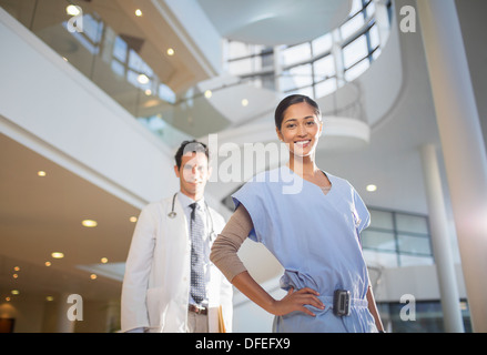 Ritratto di sorridere medico e infermiere in ospedale atrium Foto Stock