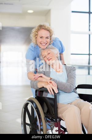 Ritratto di infermiera sorridente e paziente anziano in sedia a rotelle Foto Stock