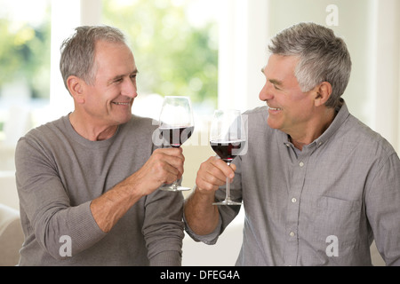 Alti uomini tostatura di bicchieri di vino Foto Stock