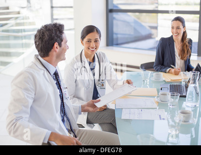 Medici e imprenditrice parlando in riunione Foto Stock