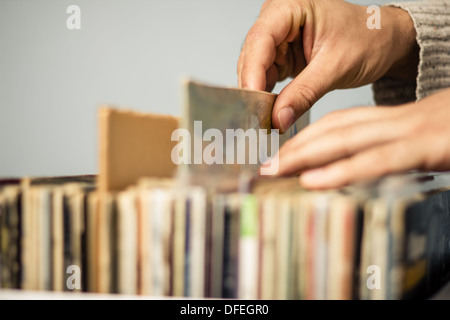 Chiudere fino alle mani di un giovane uomo come egli è la navigazione registrazioni LP Foto Stock