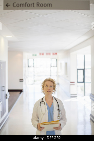 Medico guardando il segno nel corridoio di ospedale Foto Stock