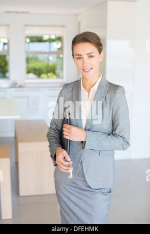 Ritratto di fiducioso agente immobiliare tenendo le chiavi di casa Foto Stock