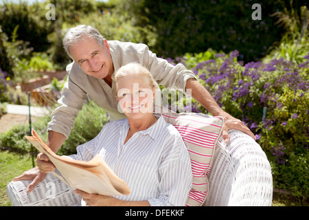 Coppia senior leggendo il giornale in giardino Foto Stock