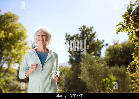 Senior donna in corsa in posizione di parcheggio Foto Stock