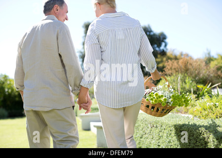 Coppia senior tenendo le mani in giardino Foto Stock