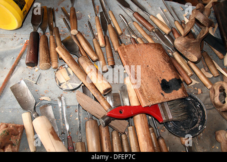 Una serie di sculture in legno di strumenti su un banco da lavoro di artigiani in un workshop in San Antonio, Ecuador Foto Stock