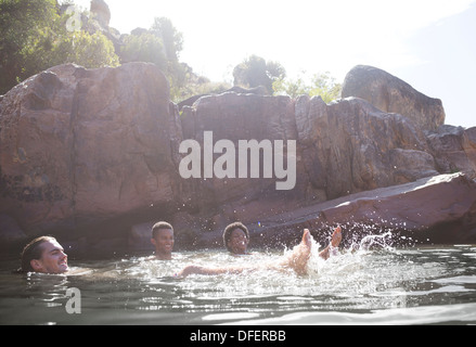 Amici a giocare nel fiume Foto Stock