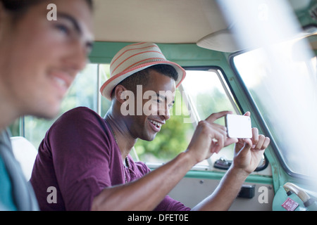 Uomo che utilizza fotocamera del telefono in camper Foto Stock