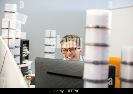Ritratto di imprenditore sorridente circondato da custodie CD Foto Stock