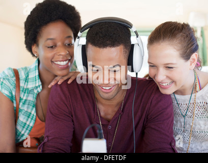 Amici che ascoltano MP3 player in auto Foto Stock