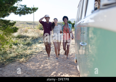 Amici per raggiungere a piedi i camper sulla spiaggia Foto Stock