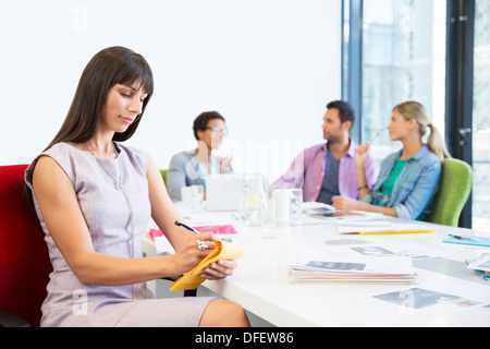 Imprenditrice prendendo appunti in riunione Foto Stock