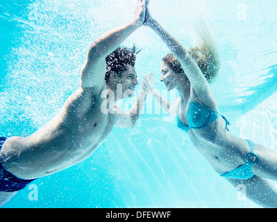 Paio di toccare le mani sott'acqua Foto Stock