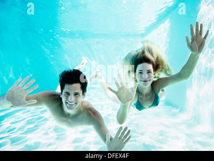 Ritratto di Coppia sorridente sott'acqua in piscina Foto Stock