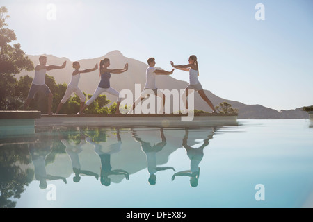 Persone che praticano il tai chi a bordo piscina Foto Stock