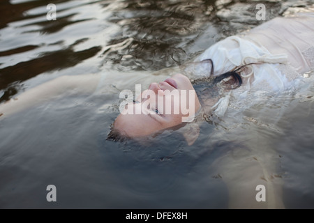 Donna galleggiante nel lago Foto Stock