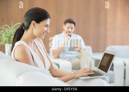 Donna che utilizza sul computer portatile sul divano Foto Stock