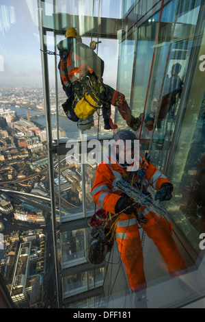 La discesa in corda doppia finestra-pulitori la pulizia della parte esterna del vetro della vista dall'osservatorio di Shard, alla sommità del grattacielo Shard, Londra, Inghilterra Foto Stock