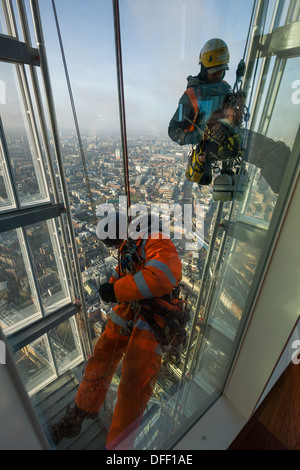 La discesa in corda doppia finestra-pulitori la pulizia della parte esterna del vetro della vista dall'osservatorio di Shard, alla sommità del grattacielo Shard, Londra, Inghilterra Foto Stock