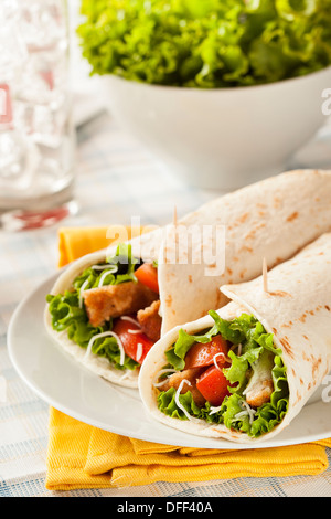 Pollo Impanato in una Tortilla avvolgere con lattuga e pomodoro Foto Stock