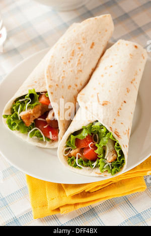 Pollo Impanato in una Tortilla avvolgere con lattuga e pomodoro Foto Stock