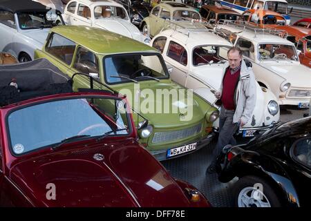 Berlino, Germania. 03 ott 2013. Un uomo guarda a vetture al vintage car meeting per della Kaefer e Trabant nella parte anteriore del palcoscenico teatro a Berlino, Germania, 03 ottobre 2013. Il 03 ottobre è la festa nazionale per commemorare la riunificazione tedesca nel 1990. Foto: JOERG CARSTENSEN/dpa/Alamy Live News Foto Stock