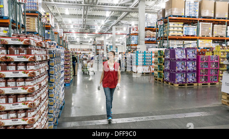 Ampio corridoio principale separa navate laterali con elementi di generi alimentari da un lato e articoli per la casa in altre in magazzino Costco NYC Foto Stock