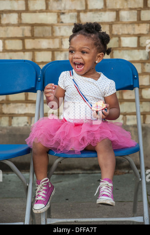 Una bambina in una rosa con tutu rosa stivali ride Foto Stock